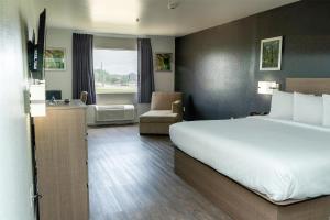 a hotel room with a large bed and a chair at Americas Best Value Inn Donaldsonville in Donaldsonville +69 photos