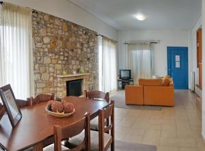 a living room with a table and a stone wall at Art Lesvos Villa 2 in Pyrgi Thermis