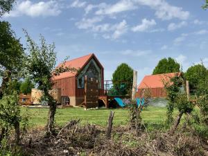 eine Scheune mit Spielplatz auf einem Feld in der Unterkunft Cabane luxe & spa extérieur Les Magnolias in Barjou + 22 Fotos