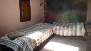 a bed with a striped comforter in a room at cabaña bodeguita de adobe in Copacabana