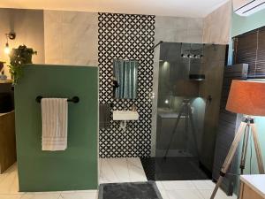 La salle de bains est pourvue d'une douche avec un mur vert. dans l'établissement Southern Comfort Guest House, à Bellville 19 autres photos