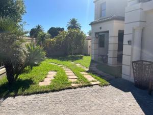 un jardin avec une allée à côté d'une maison dans l'établissement Southern Comfort Guest House, à Bellville
