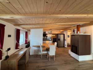 cocina y comedor con techo de madera en Appartamento Cima 12, en Pozza di Fassa
