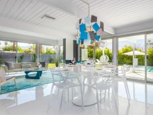 a dining room with a white table and chairs at As seen on HGTV Desert Flippers The Pink Door in Palm Springs