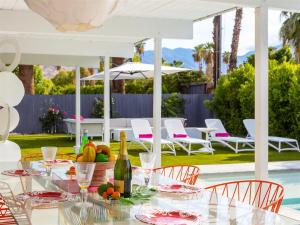 a table with a bottle of wine and fruit on it at As seen on HGTV Desert Flippers The Pink Door in Palm Springs