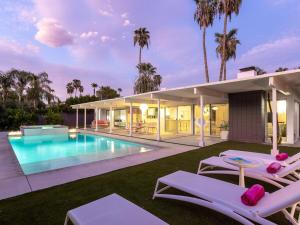 an exterior view of a house with a swimming pool at As seen on HGTV Desert Flippers The Pink Door in Palm Springs