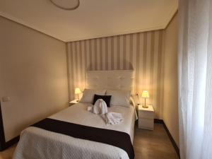 Un dormitorio con una cama con dos toallas encima. en Rooms Castro Centro, en Castro Urdiales 5 fotos más