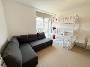 a living room with a couch and a book shelf at Penthouse on the Grange in London