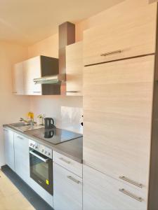 a kitchen with white cabinets and a stove at Balkonliebe Karlsruhe - Waschmaschine, Stellplatz, Balkon, Regendusche in Karlsruhe +3 photos