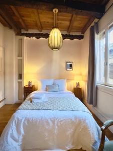 una camera da letto con un letto bianco e una lampada a sospensione di La Bohème Saint Michel by Art&Suites a Gaillac
