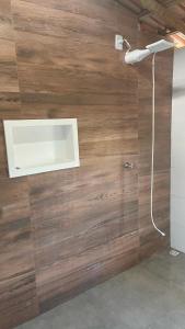y baño con ducha y pared de madera. en Hospedaria Coisa Linda Caraiva, en Caraíva 10 fotos más