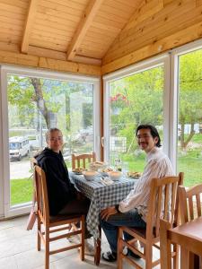 a man and woman sitting at a table in a house at Bujtina Arlindi in Valbonë