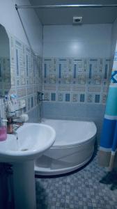a bathroom with a white tub and a sink at MUSLIMA HOTEL Boutique in Bukhara