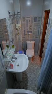 a bathroom with a white sink and a toilet at MUSLIMA HOTEL Boutique in Bukhara +24 photos