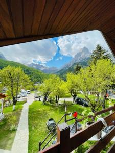 a balcony with a view of a park with mountains at Bujtina Arlindi in Valbonë