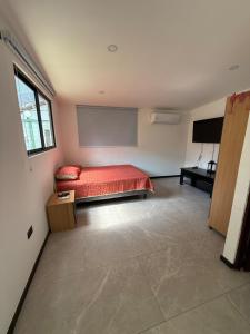 a bedroom with a red bed and a large window at Casa Santoni in Quebrada Ganado +8 photos