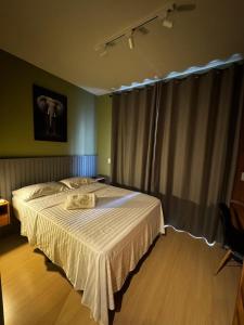 a bedroom with a large bed with a white blanket at Studio Avenida Paulista - Nex One Consolação in Sao Paulo