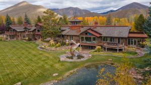 a large log home with mountains in the background at Apres Lodge 5 Bedroom in Hailey