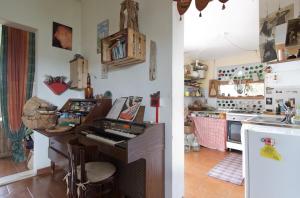two pictures of a kitchen with a piano in a room at natural farm with sea view in Isola Ruia +26 photos