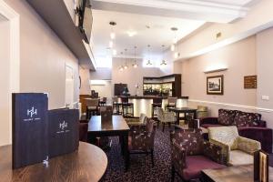 a restaurant with tables and chairs and a bar at Halifax Hall in Sheffield