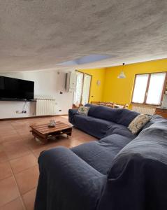 un soggiorno con un divano blu e un tavolo di Lucky House a Borghetto di Vara