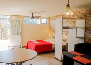- une chambre avec un lit doté d'une couverture rouge et d'une table dans l'établissement Manadelmar, à Las Gaviotas