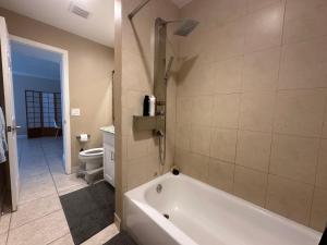 a bathroom with a tub and a toilet at Downtown Boca Apt in Boca Raton +7 photos
