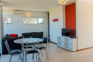 une pièce avec une table, des chaises et une télévision dans l'établissement Manadelmar, à Las Gaviotas