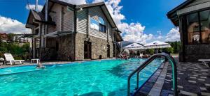 a pool at a hotel with people in the water at Whiteberry Studio in Bukovel