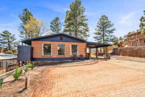 ein Backsteinhaus mit einem schwarzen Dach in der Unterkunft NEW! HUGE 5BR Mountain Views Game Room Hot Tub Lawn Games BBQ in Flagstaff