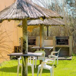 un groupe de tables et de chaises devant une cabane dans l'établissement Manadelmar, à Las Gaviotas