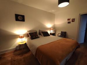 a bedroom with a bed with two lamps on it at Suite - Chambre Cherry Plum in Coulommiers