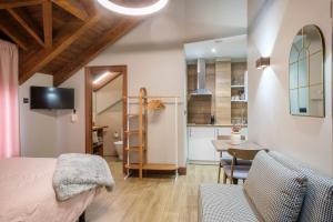 a bedroom with a bed and a table and a kitchen at El Rincón de Andrea Estudios in Biescas