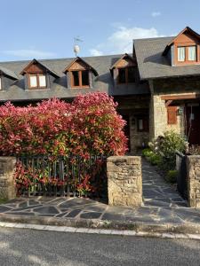 a house with a fence and flowers in front of it at El Mirador d'Olp in Olp