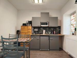 a kitchen with a table and chairs and a microwave at Löwen Haus am Edersee in Vöhl