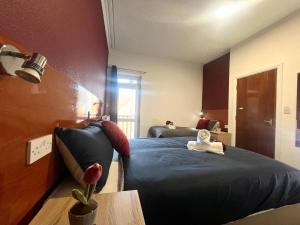 a bedroom with a blue bed and a table and a window at Cozy one bedroom flat sleeps 5 Skegness F6 in Skegness