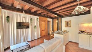 a living room with a couch and a kitchen at Ca'Dinora - Venetia apartment - in Bardolino