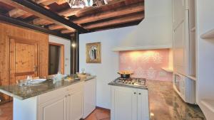 a kitchen with white cabinets and a stove top oven at Ca'Dinora - Venetia apartment - in Bardolino +26 photos
