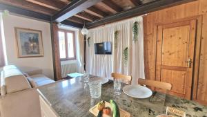 a kitchen with a table and a living room at Ca'Dinora - Venetia apartment - in Bardolino