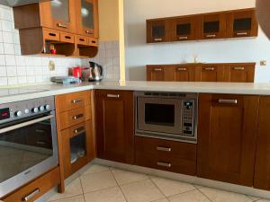 a kitchen with wooden cabinets and a stove top oven at Sweet Home Nea Roda! in Nea Roda