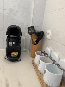 czarny blender stojący na blacie obok kubków w obiekcie Le cocon d'Océ - WIFI, PARKING, ARRIVEE AUTONOME, à 15 minutes de la plage w Béziers +3 zdjęcia