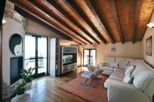 a living room with a couch and a tv at Lake Breeze Salò in Salò