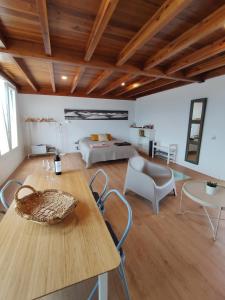 a room with a table and chairs and a bed at Loft Casa Burgao in Caleta de Caballo