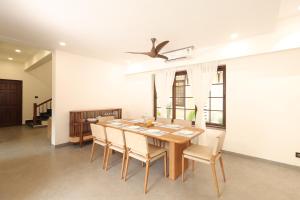 a dining room with a wooden table and chairs at Tabula Rasa By Casa Eternal Villas - Morjim in Morjim