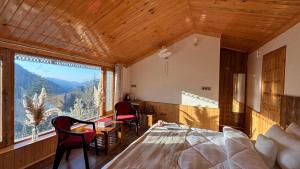 a bedroom with a bed and a large window at Kaushalya Homes in Shimla