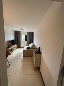 a living room with a couch and a television at Apartamento próximo a praia in Maceió +2 photos