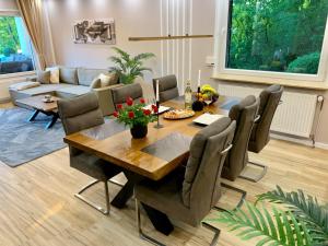 a living room with a wooden table and chairs at Bergliebe 5 mit großer Terrasse, Tiefgarage & Lift in Bad Harzburg