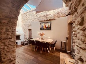une cuisine et une salle à manger avec une table et des chaises dans l'établissement La maison du Bougainvillier 10 personnes, à Dions