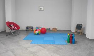 Marina di AsceaにあるVS Le Terrazze degli Dei - Villa con giardino, palestra, area giochi per bimbiの青いマットと赤い椅子が備わる客室です。