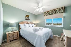 a bedroom with a bed with a ceiling fan and a window at Driftwood Towers 5F in Gulf Shores